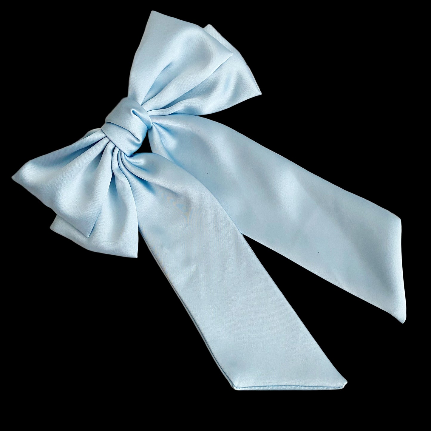 Light blue satin bow on a light wooden surface