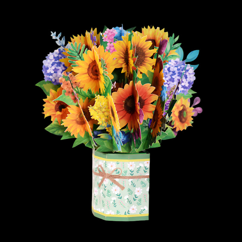 Colorful bouquet of sunflowers and other flowers in a decorative tin on a pink background