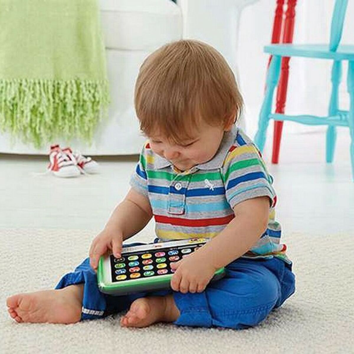 Child playing with a toy phone on a carpeted floor