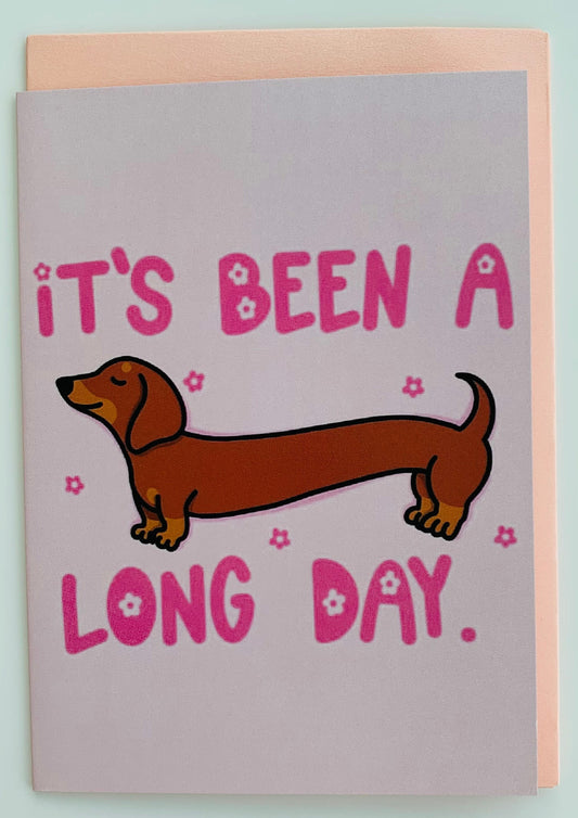 Card with a dachshund illustration and text 'It's been a long day' on a light blue background