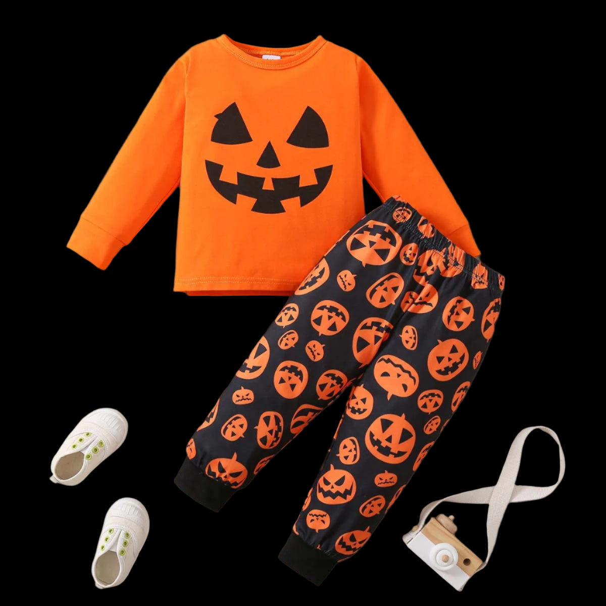 Halloween-themed outfit with orange shirt and black pants featuring pumpkin patterns on a wooden surface.