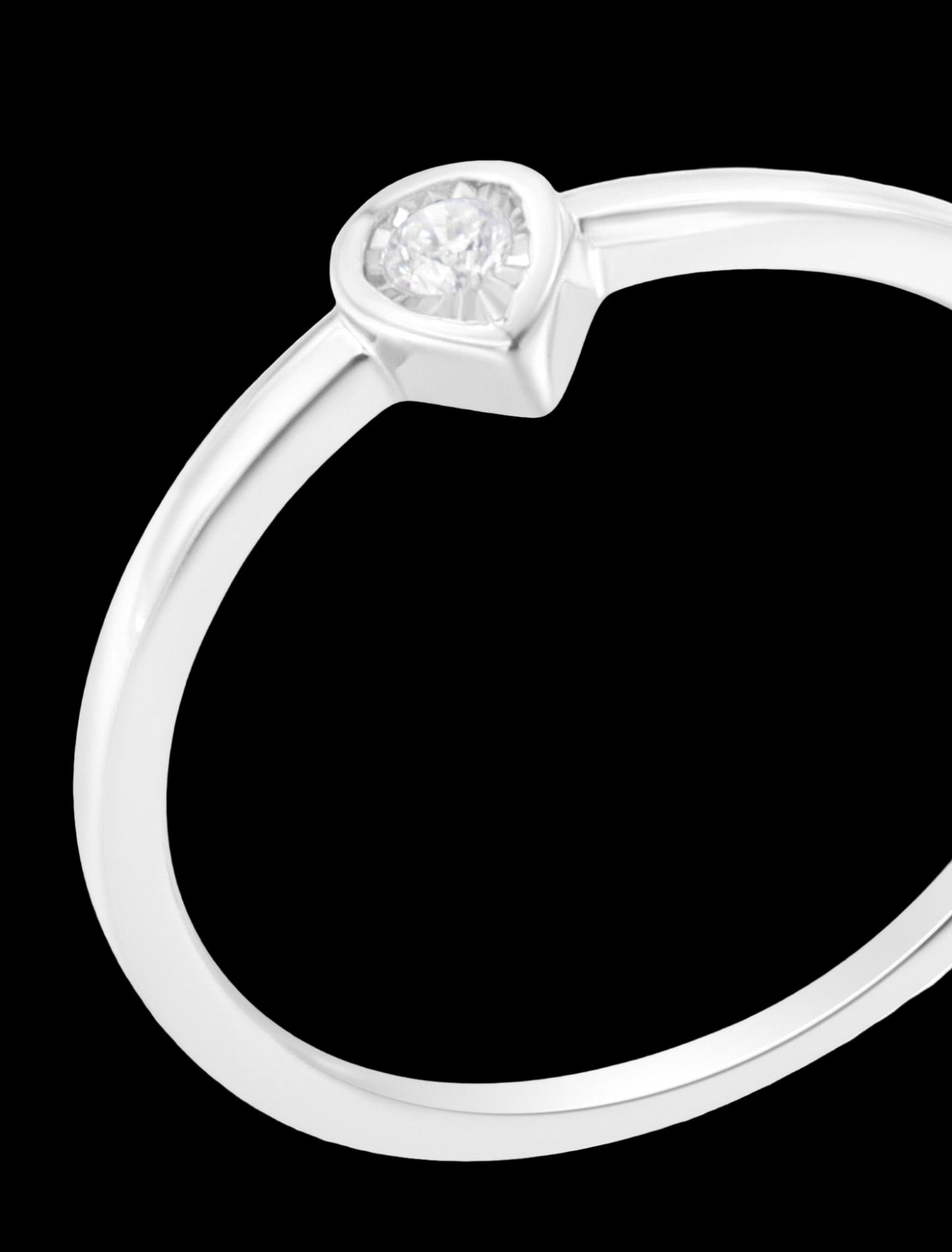 Silver ring with a heart-shaped diamond on a white background