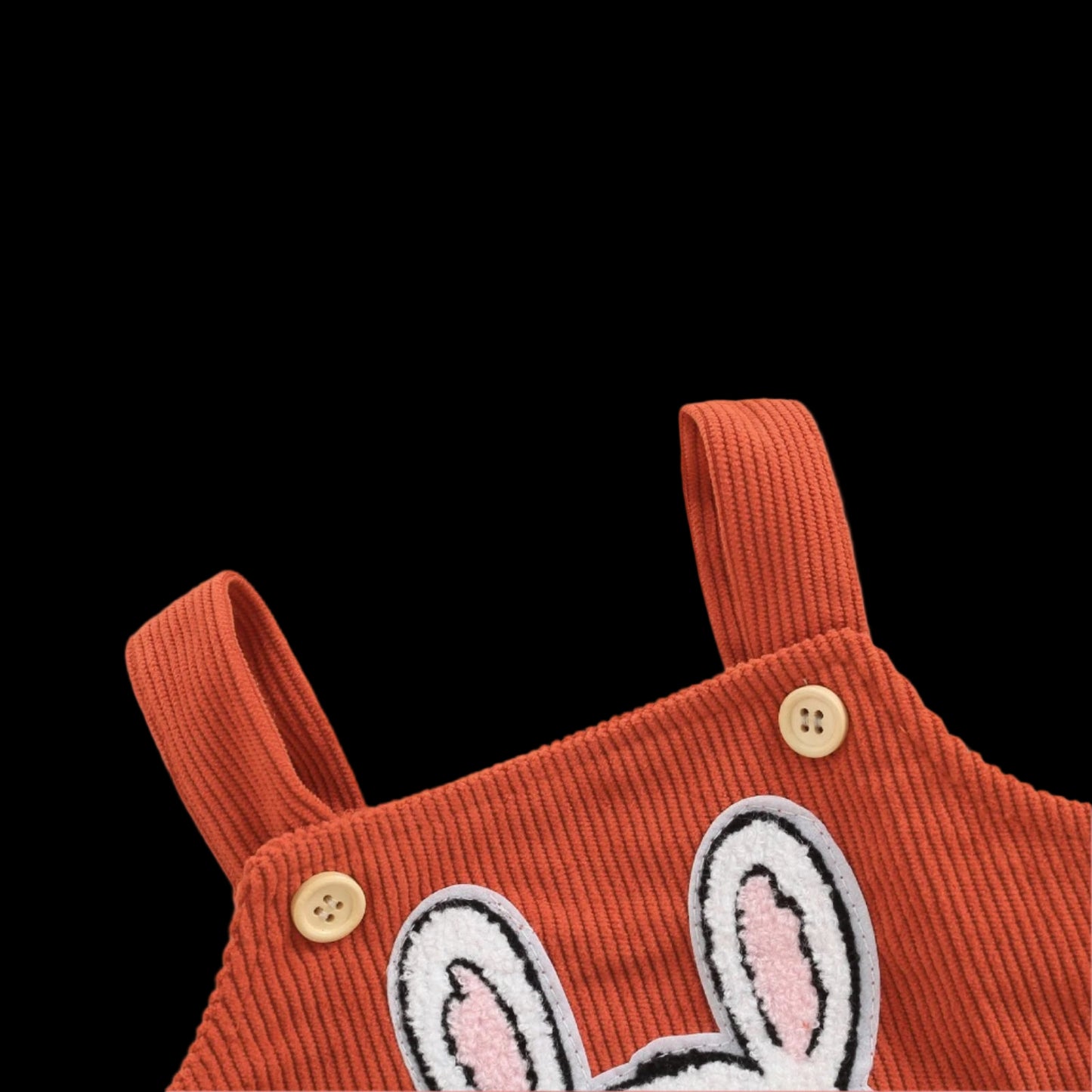 Red corduroy romper with bunny patch on a beige background