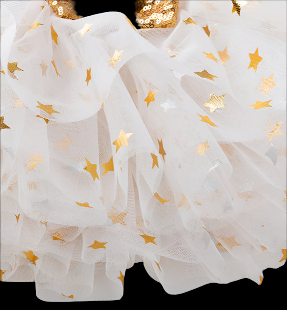 Red Christmas-themed outfit with white tutu and gold accents on a wooden surface.