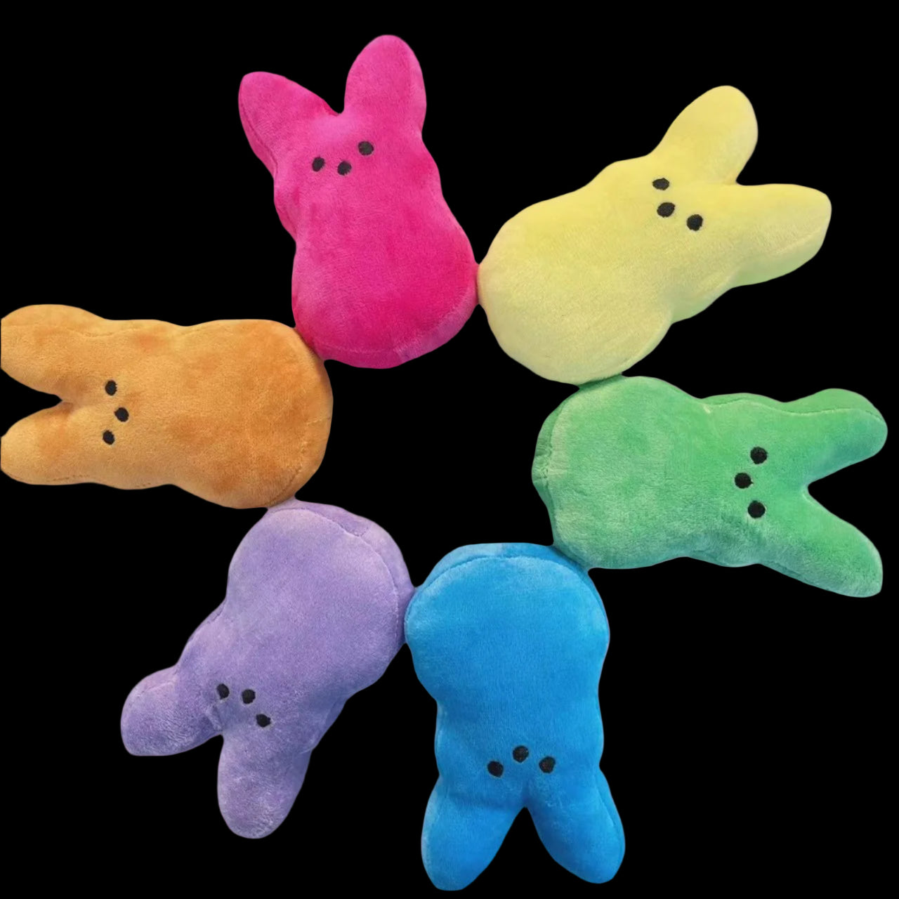 Colorful plush toys shaped like bunnies on a white background
