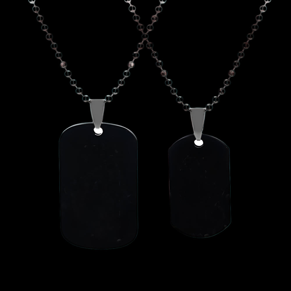 Two black dog tag pendants on silver beaded chains against a white background