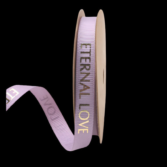 Spool of purple ribbon with 'Eternal Love' text on a white background