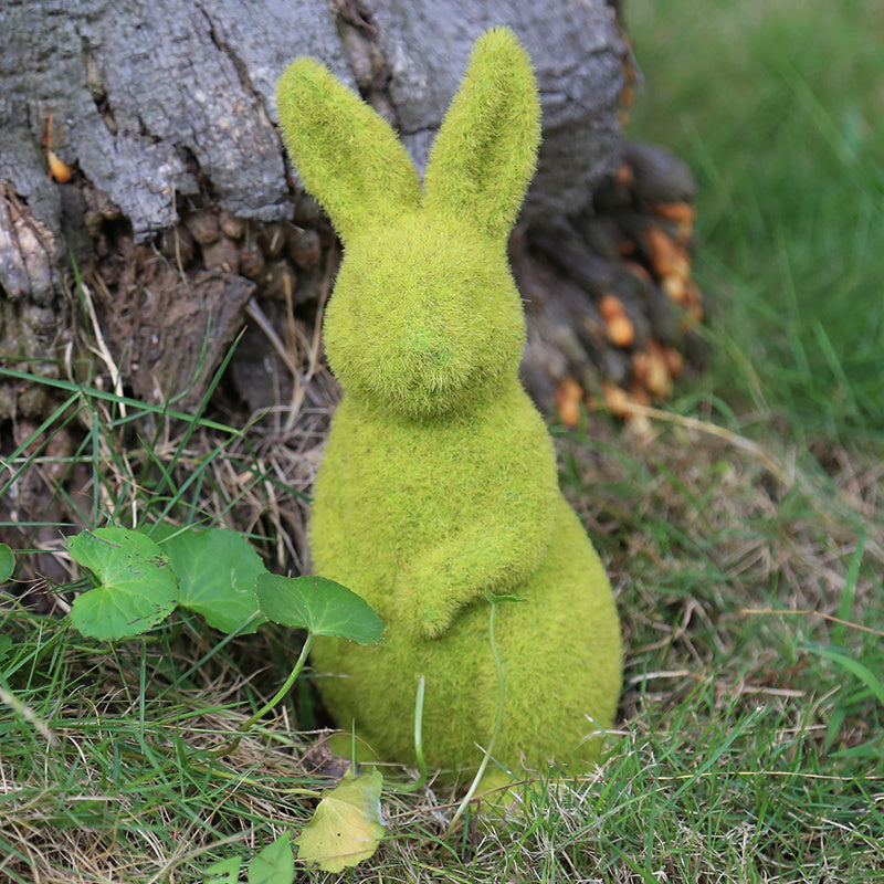 Green moss rabbit sculpture against a natural background