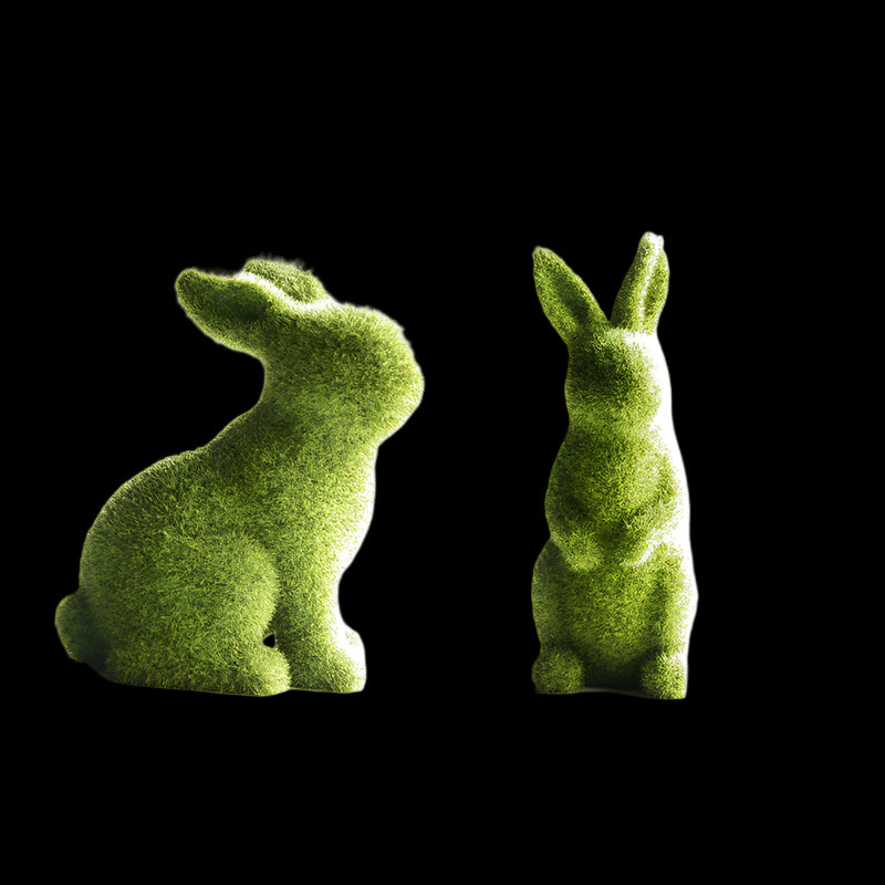 Two green moss-like rabbit sculptures on a white background