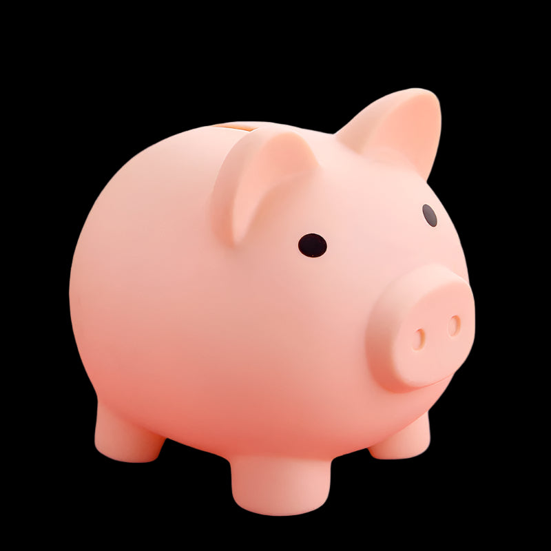 Pink piggy bank on a pink surface with a blurred background