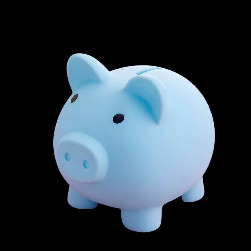 Blue piggy bank on a pink surface with a blurred background