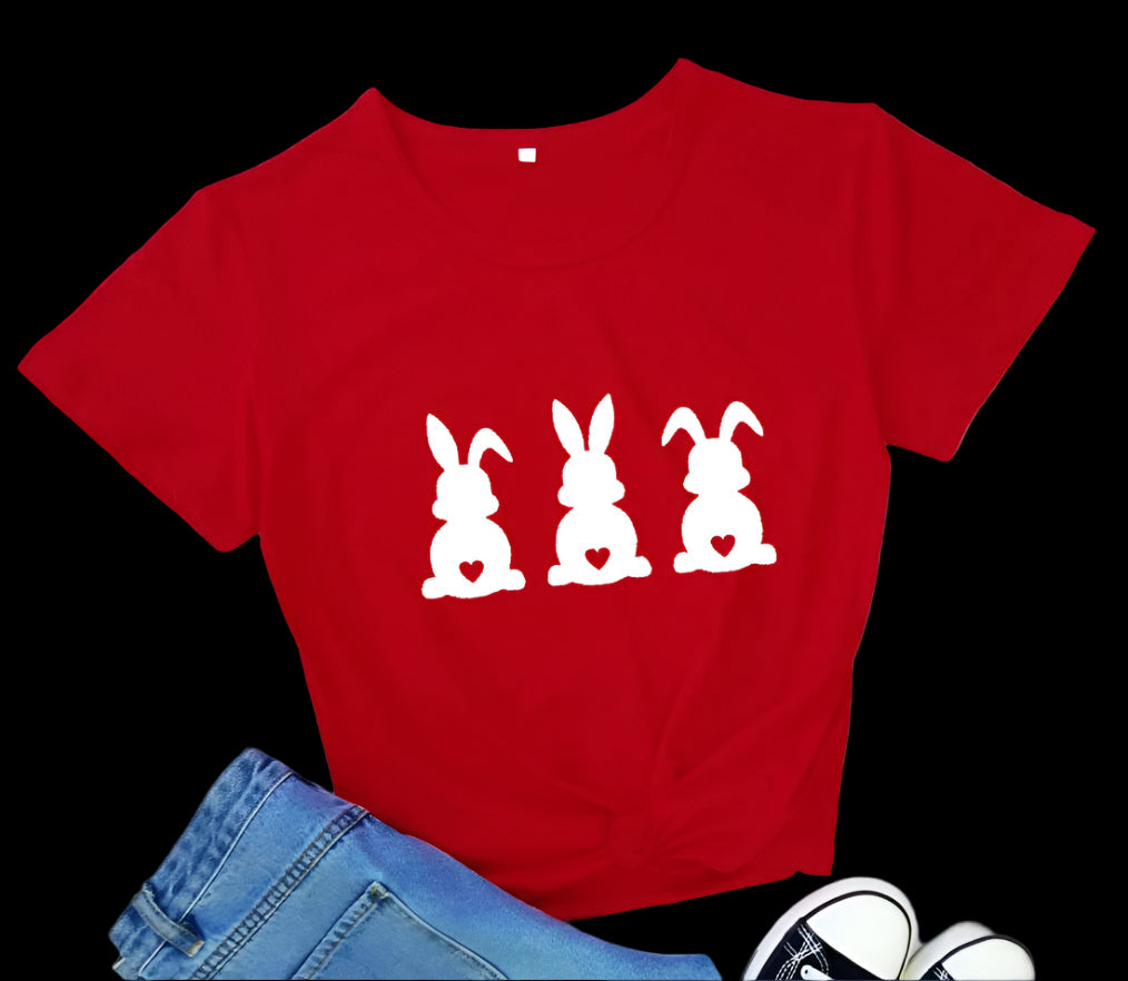 Red t-shirt with white bunny graphics on a wooden floor