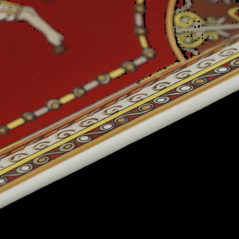 Decorative edge of a red and gold card with intricate patterns on a black background