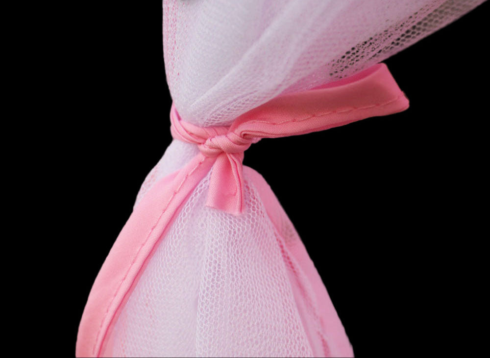 Close-up of a pink mesh bag with a knot on a blurred green background