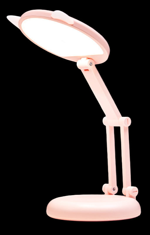 Pink desk lamp on a white surface with a pink background