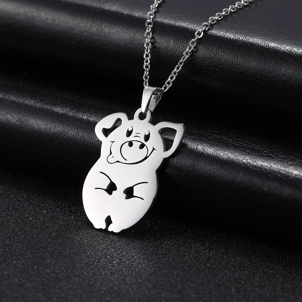 Silver pig-shaped pendant on a chain against a black background