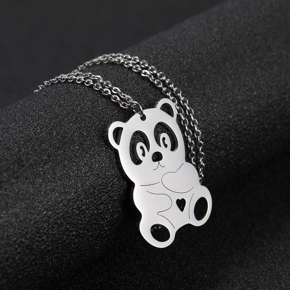 Silver pendant shaped like a cartoon bear on a black background