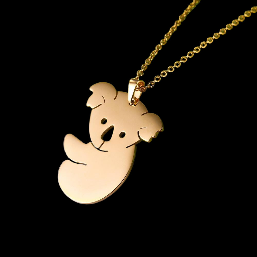 Gold angel pendant necklace on a green fabric background