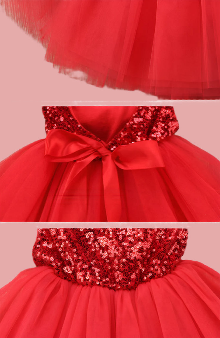 Red dress with sequin details and a bow on a wooden surface