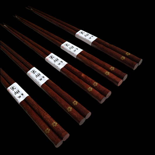 Set of wooden chopsticks with labels on a textured paper background