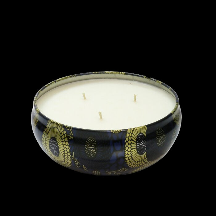 Candle in a decorative black holder with gold patterns on a white background