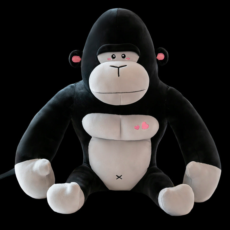 Plush monkey toy with black fur, white face, and pink heart designs on a light background.