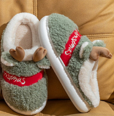 Four pairs of slippers with reindeer ears on a beige couch.