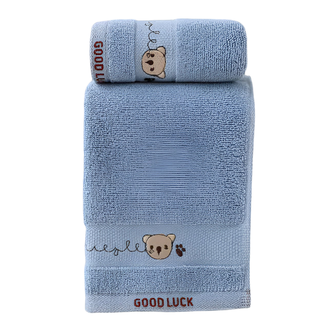Two blue towels with teddy bear designs and 'Good Luck' text on a white surface.