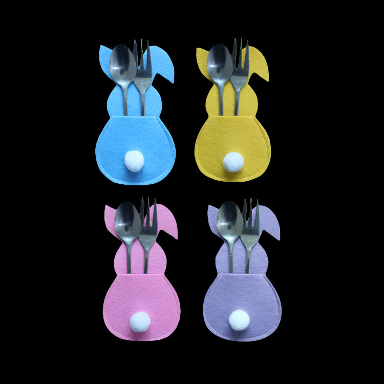 Four colorful bunny-shaped cutlery holders with spoons and forks on a white background