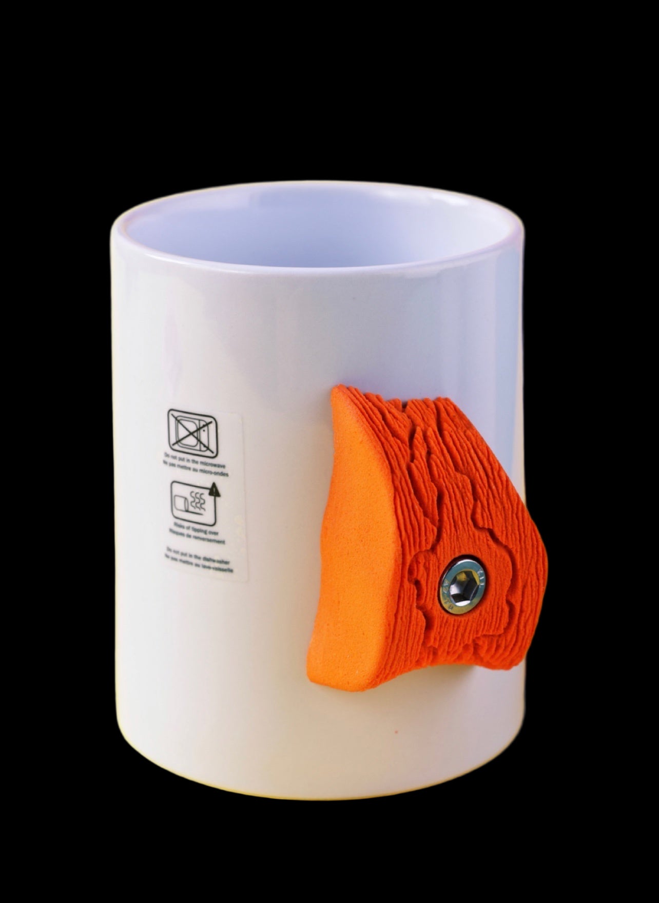 White mug with an orange fish-shaped handle on a yellow background