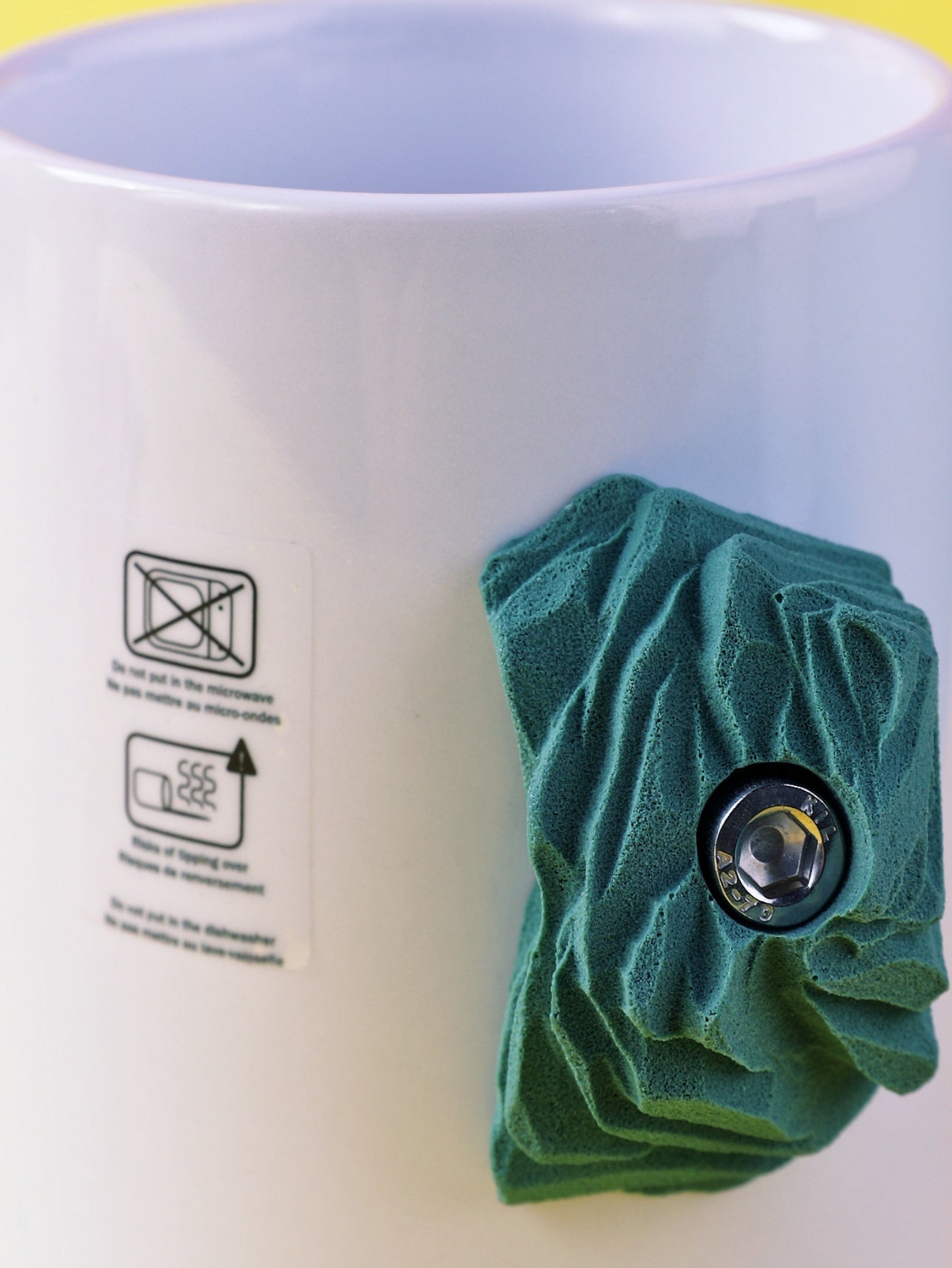 Green textured mug cozy on a white mug with care instructions.