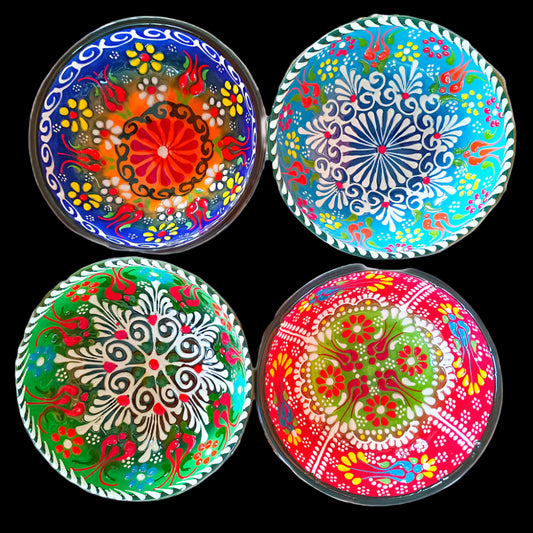 Four colorful decorative plates with intricate patterns on a white background