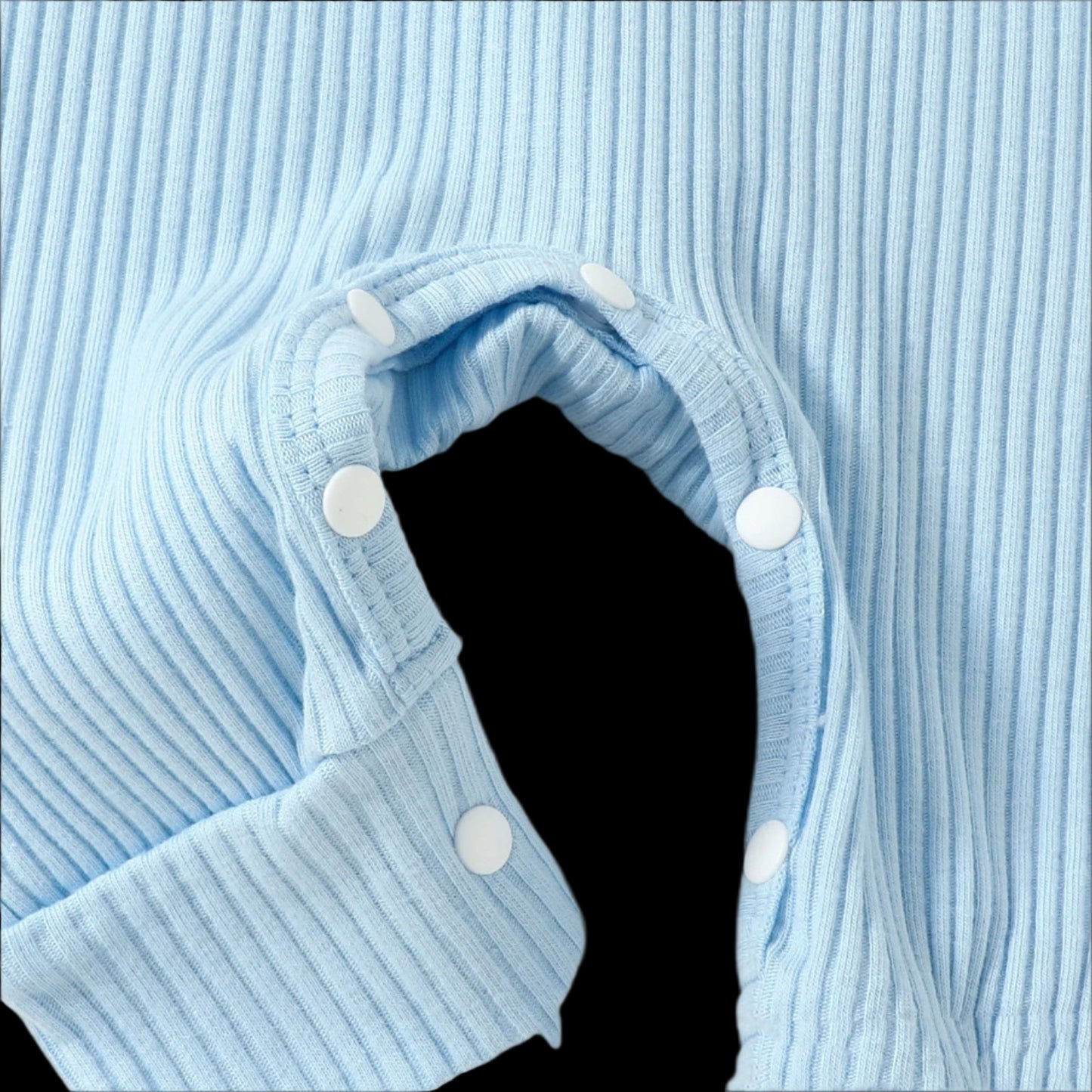 Close-up of a blue ribbed garment with white buttons on a light blue background