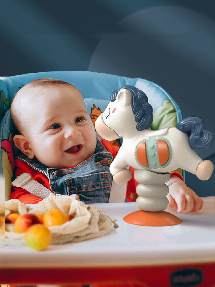 Baby in a high chair with a toy and fruits on a blue background