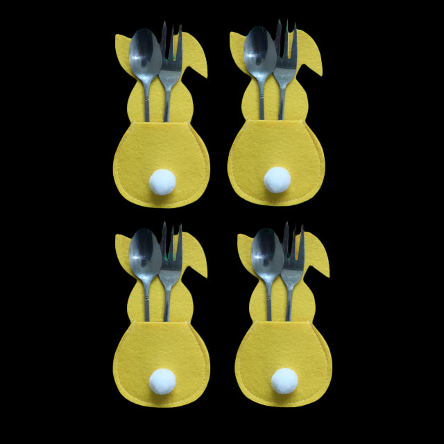 Four yellow bunny-shaped cutlery holders with spoons and forks on a white background