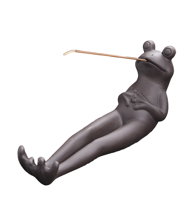 Frog-shaped incense holder on a wooden surface