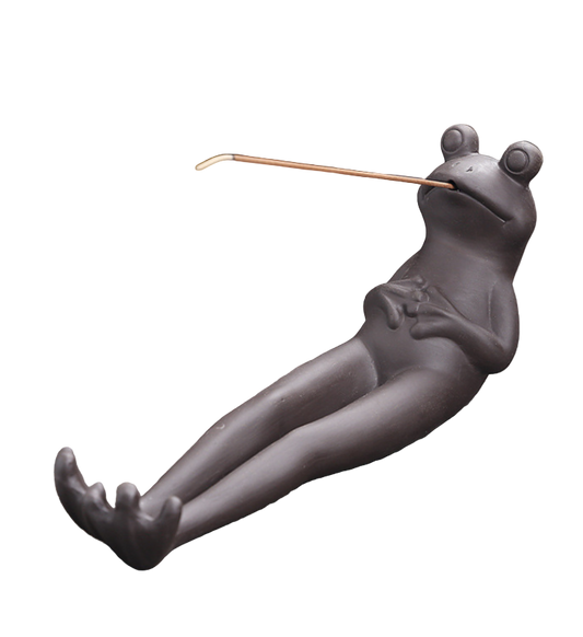 Frog-shaped incense holder on a wooden surface