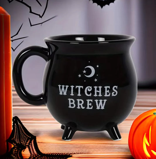 Black mug with 'Witches Brew' text on a Halloween-themed background with pumpkin and candle.