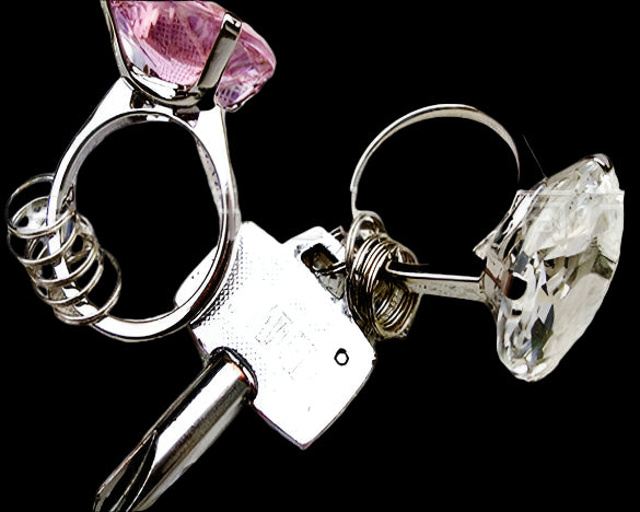 Pair of earrings with pink and clear gemstones on a textured surface