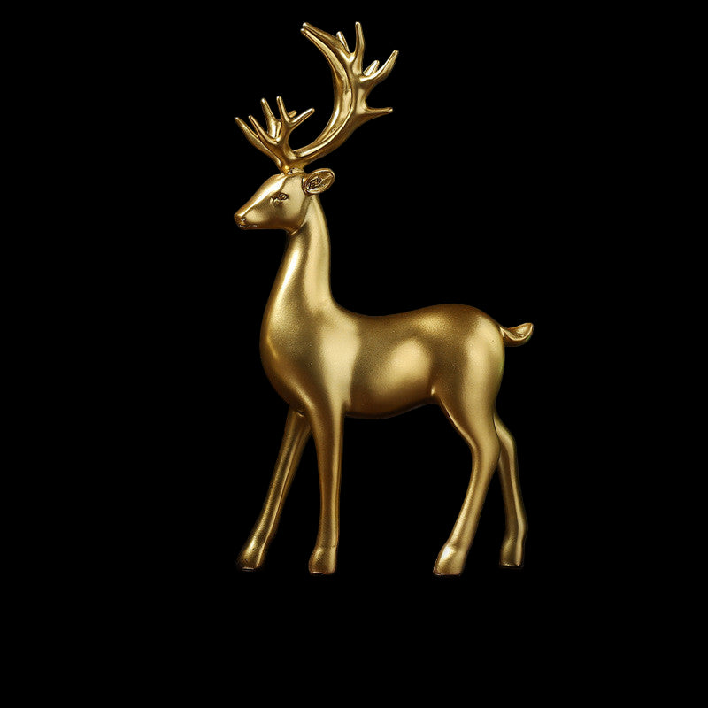 Gold deer figurine on a reflective surface with a dark background