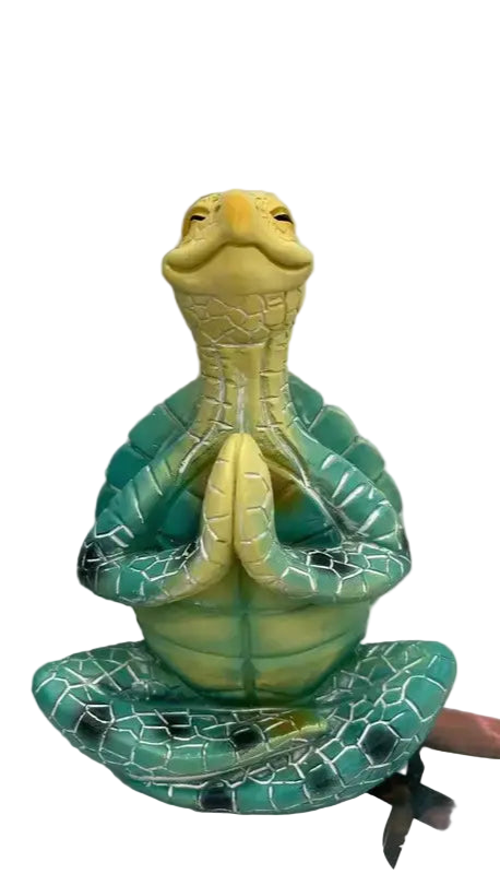 Decorative turtle figurine on a white surface with a gray wall background