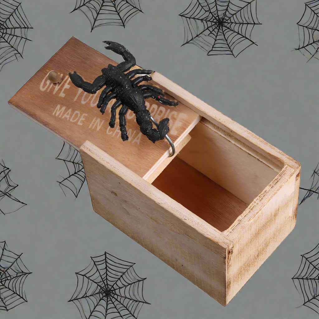 Wooden box with a black scorpion figurine on a white background