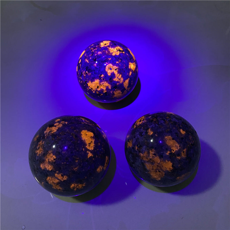 Three glowing blue and orange spheres on a reflective surface