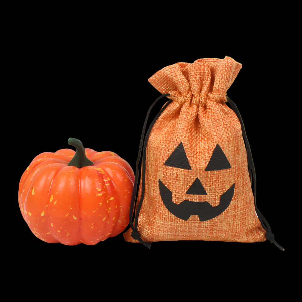 Halloween-themed drawstring bag with pumpkin face design next to a small orange pumpkin on a white background