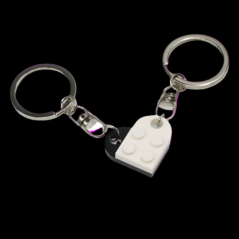 Keychain with heart-shaped black and white keyring and a white brick design on a white background