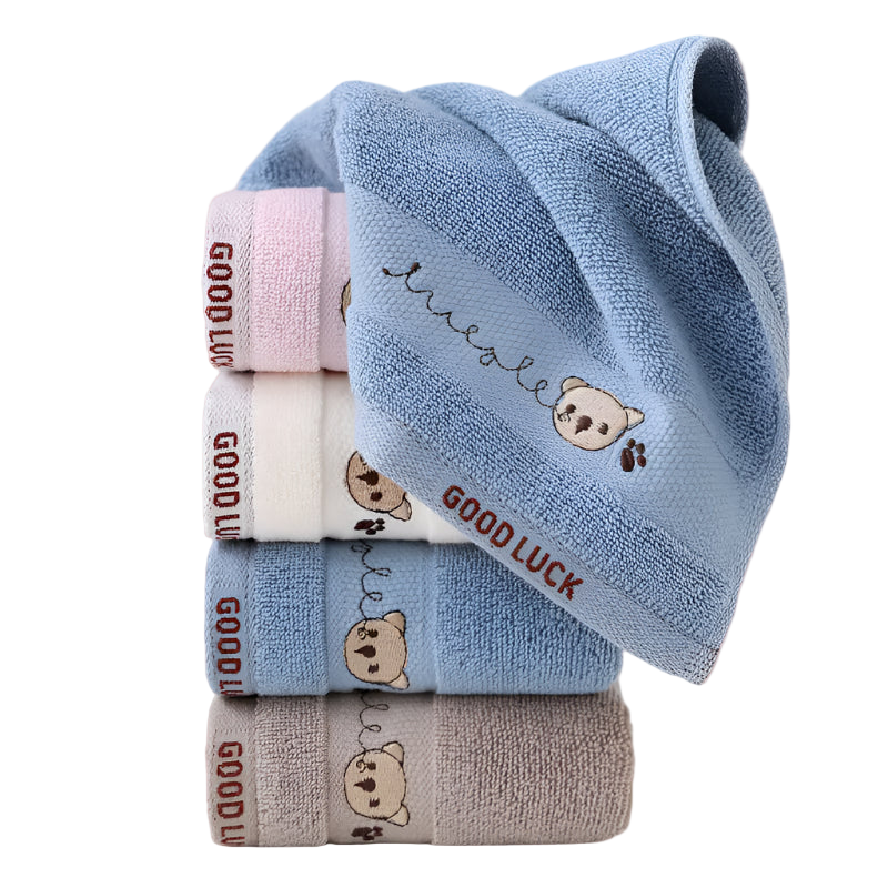 Stack of folded baby towels with teddy bear designs and 'Good Luck' text on a white background