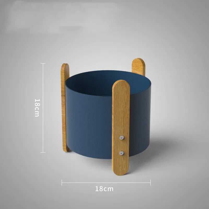 Blue cylindrical container with wooden handles on a gray background
