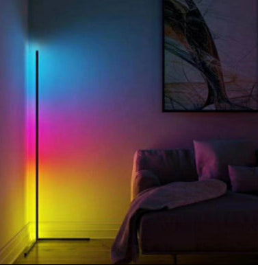 Colorful LED floor lamp in a room with a couch and abstract painting.