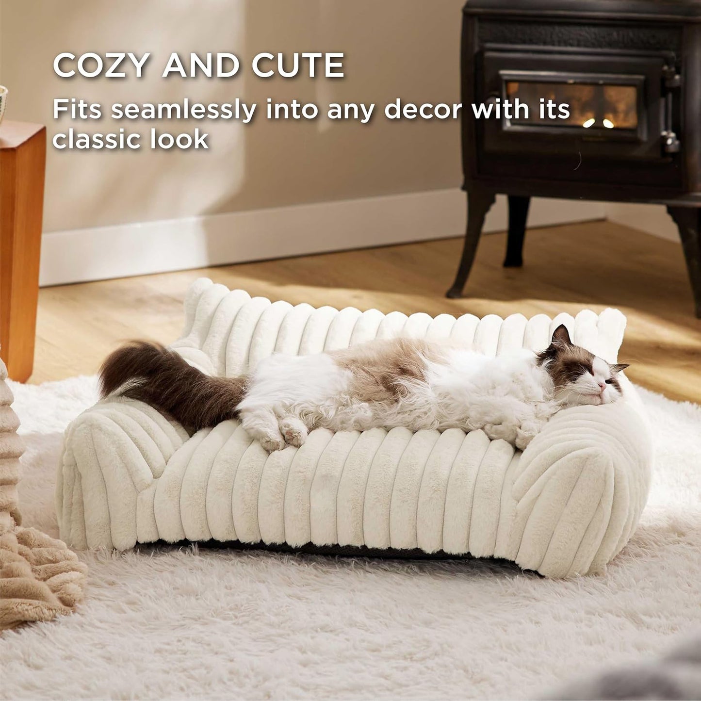 White pet bed with two cats on it in a cozy living room setting.
