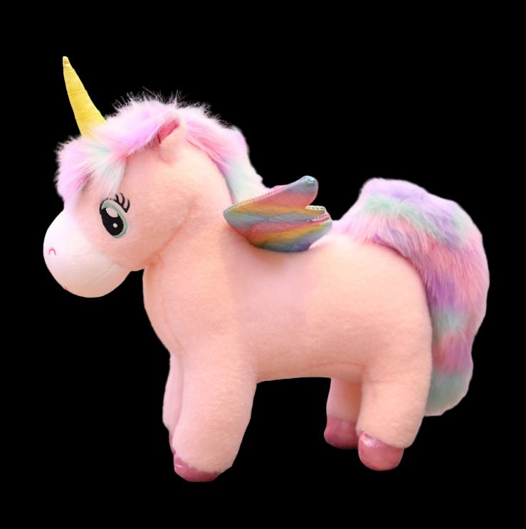Plush unicorn toy with rainbow hair and wings on a wooden floor.